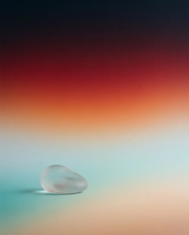 A minimalist still life featuring a translucent, pebble-shaped glass object resting on a softly gradient backdrop of warm oranges and cool blues. The mood is tranquil and contemplative, with an emphasis on abstract forms and subtle lighting.