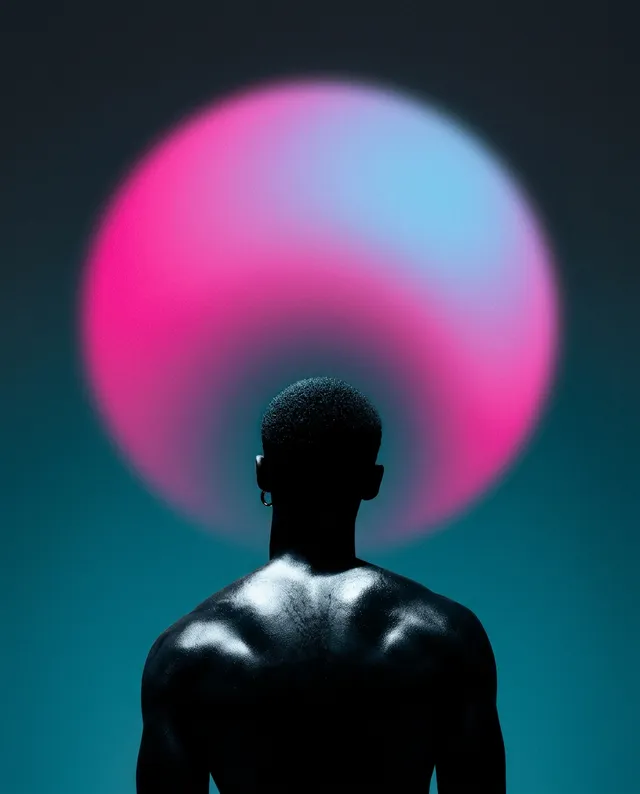 A striking editorial photograph features a silhouetted figure with a muscular back, set against a vibrant gradient backdrop of pink and blue hues, evoking a sense of mystery and introspection. The soft glow of the oversized circular light creates an ethereal mood, drawing attention to the subject's poised presence.