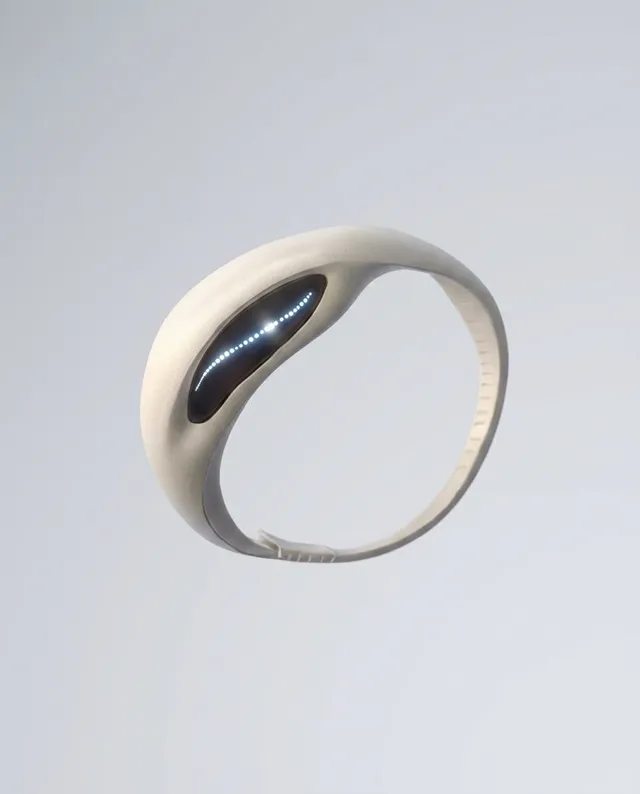 This sleek, futuristic wearable device features a smooth, minimalist design with a soft white exterior and a dark, illuminated display. The image employs digital rendering techniques, exuding a high-tech and innovative mood against a neutral backdrop.