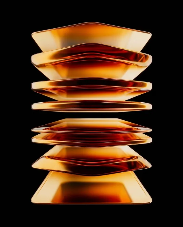 This editorial photograph features a stack of elegantly shaped glass plates, showcasing smooth, reflective surfaces in warm amber and gold tones. The minimalist composition against a stark black background creates a contemporary and sophisticated mood.