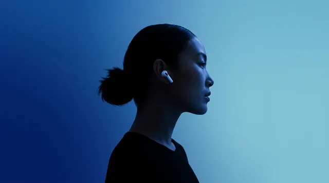 A sleek profile of a woman wearing AirPods is set against a gradient of deep blue tones, creating a modern and minimalist aesthetic. The mood is calm and sophisticated, emphasizing the elegance of the subject and the technology.