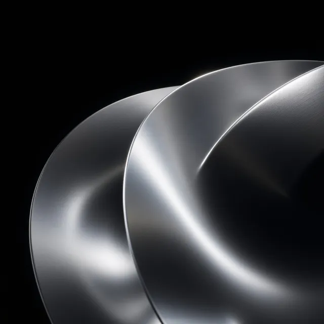 A close-up of polished metallic plates overlapping, showcasing a sleek and modern design. The image features a minimalist aesthetic with high contrast, highlighted by cool silver tones against a deep black background, conveying a sense of elegance and sophistication.