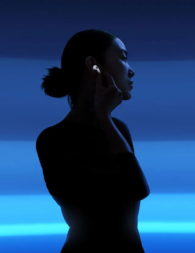 A sleek silhouette of a woman wearing earbuds is set against a striking blue gradient background, evoking a modern and minimalist aesthetic. The mood is serene and stylish, with cool tones dominating the visual.